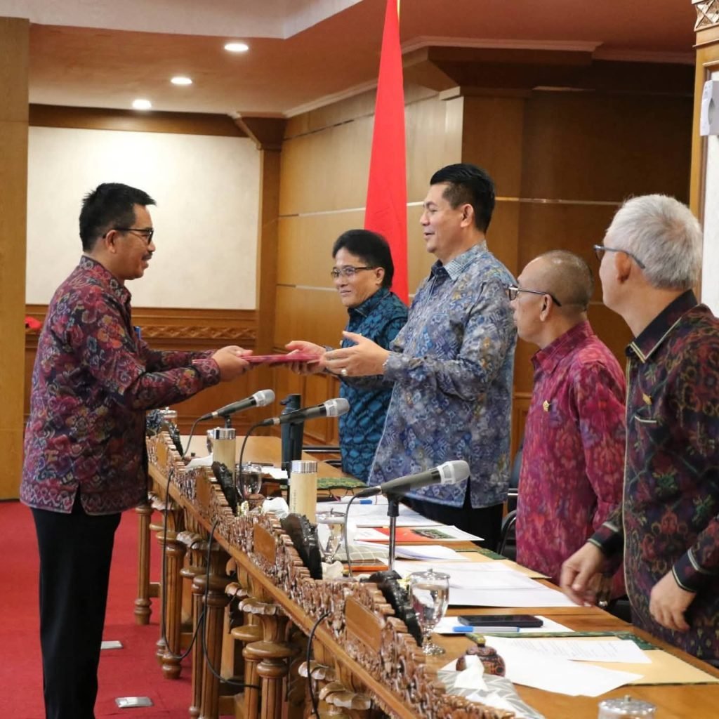 Ket Foto Ist: Pembacaan Penyampaian Laporan dari anggota DPRD Bali Nyoman Budiutama, perihal Raperda perubahan Perda Nomor 1 Tahun 2024 Tentang Pajak dan Retribusi Daerah, untuk dapat dilanjutkan proses penetapannya menjadi Perda, Senin (18/5/2026).