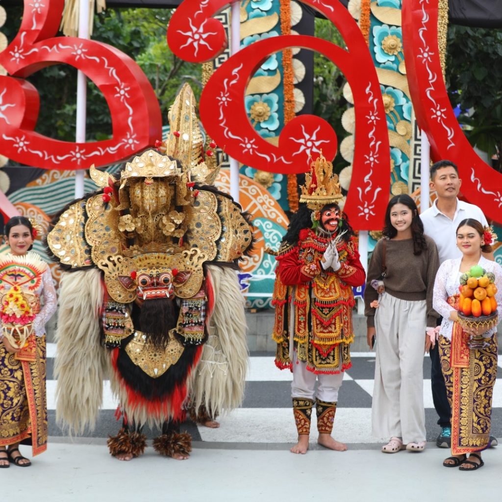 Ket Foto Ist: Tampak keakraban wisatawan dengan seniman barong dan tari jauk dalam momentum parade gebogan, di kedatangan Bandara Internasional I Gusti Ngurah Rai, Badung, Jumat (3/7/2026).